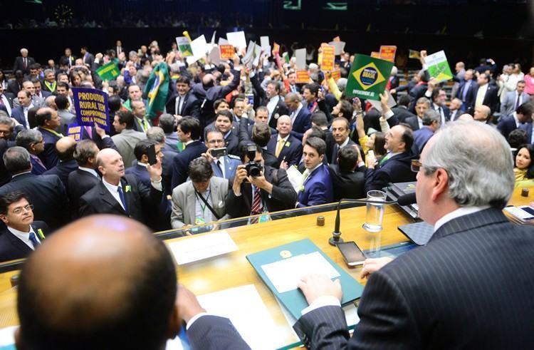 O plenário está quase lotado e parlamentares seguram cartazes com dizeres favoráveis e contrários ao impeachment. (Foto: Nilson Bastian/ Câmara dos Deputados)